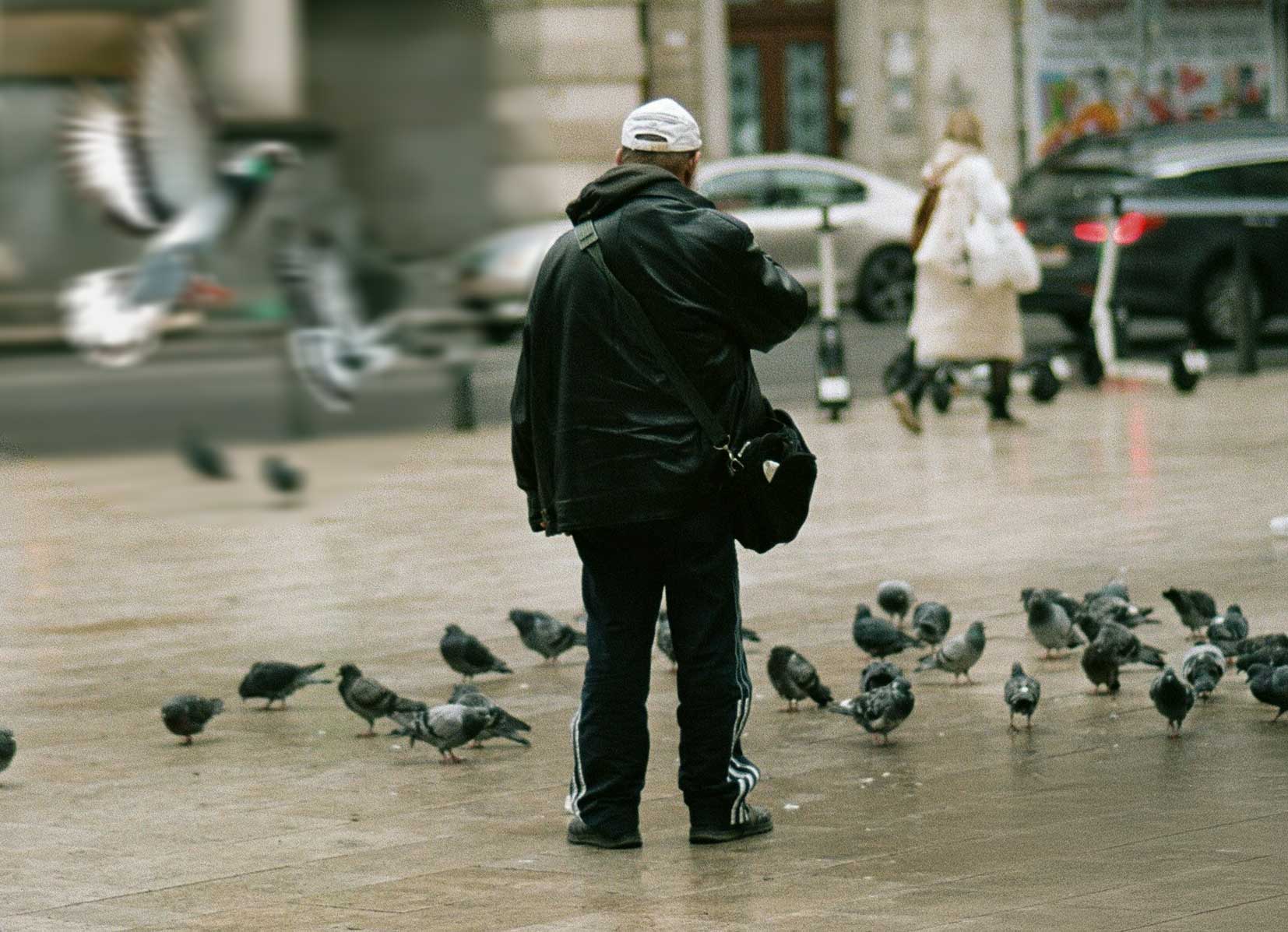 Persoon uit de doelgroep van Levensloopaanpak op plein met duiven